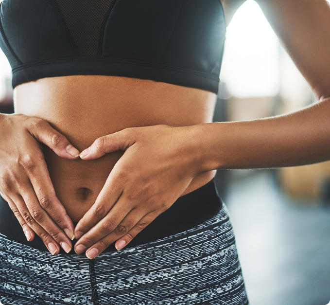a person holding a heart shape on their belly
